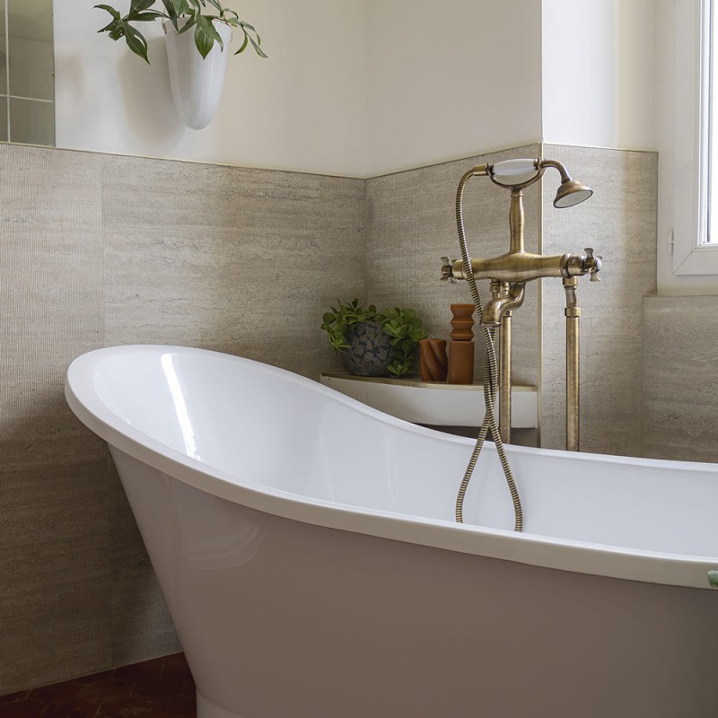 Carrelage mural effet travertin Vein Cut Classic Arpa en relief 60x120 cm dans une salle de bain élégante avec baignoire îlot