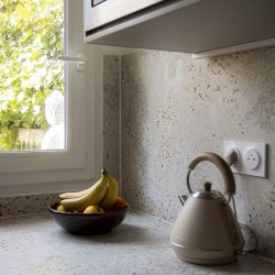 Zoom sur le carrelage effet pierre terrazzo SCG Patchy avec sa texture beige-gris ponctuée de grains naturels