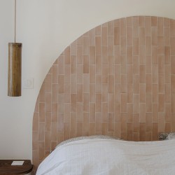 Carrelage effet zellige Coco couleur rose en tête de lit en forme d'arche.