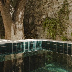Carrelage effet zellige Roots couleur bleu roi dans une piscine. A l'ombre des arbres dans une bâtisse provençale