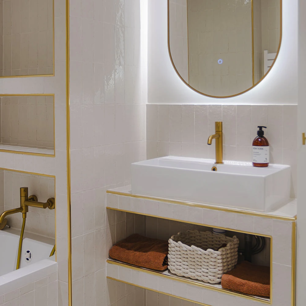 Vasque et miroir dans salle de bain carrelage blanc brillant