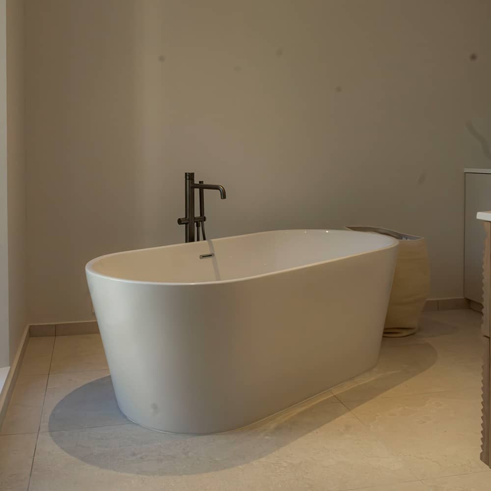 Ambiance lumineuse : carrelage effet pierre calcaire clair ivoire/blanc en salle de bain.