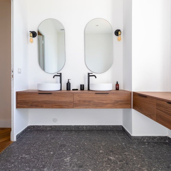 Contraste chic : carrelage effet pierre calcaire noir mat, style hôtelier en salle de bain.